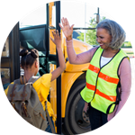 woman giving girl high five at school bus door